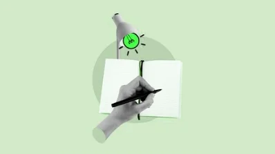 Hand writing in an open notebook under a lightbulb, symbolizing creative services by a creative services company for rebranding and brand refresh on the Rebranding & Brand Refresh page
