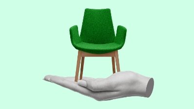Offline Print Design Services featuring a creative visual of a green chair balanced on a hand, symbolizing the precision of print design solutions