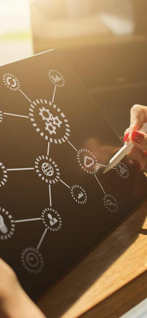 A person typing on a laptop with puzzle pieces and icons floating around, representing PIM Implementation Services and Pimcore digital asset management for efficient workflow